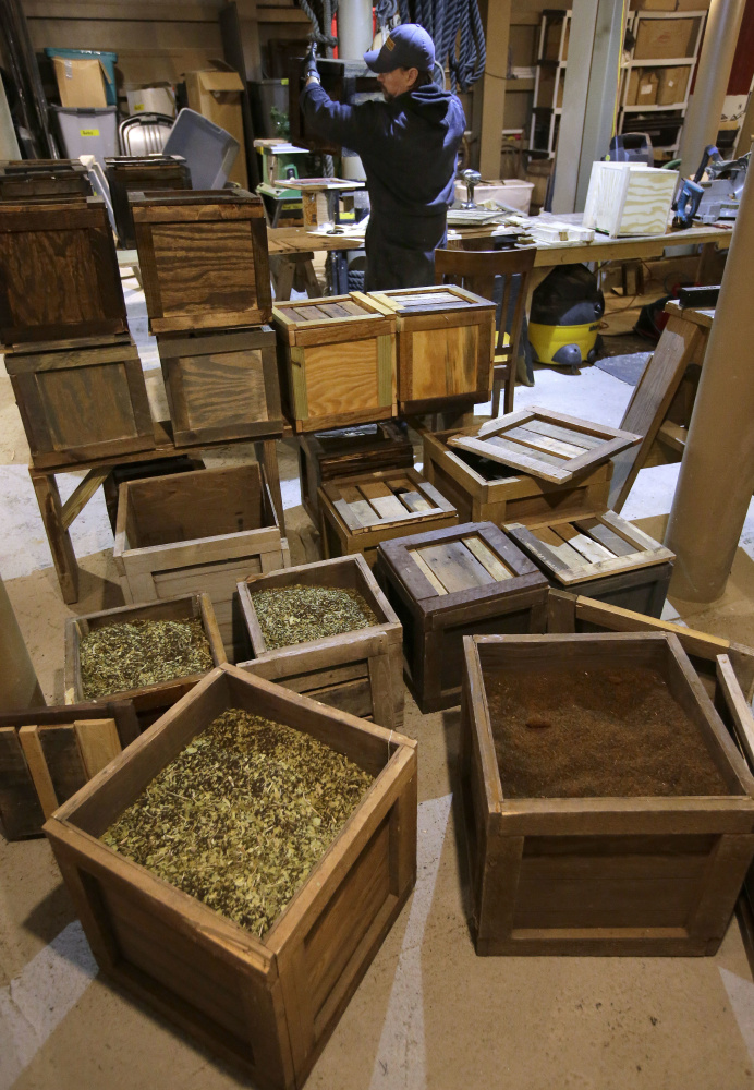 Luis Cardona prepares replicas of historic tea containers, foreground, at the Boston Tea Party Museum in preparation for Saturday's re-enactment of the historic act of defiance in 1773.