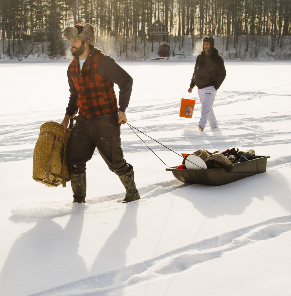 With the temperature at 10 below zero, the breath of ice fishermen Mike Racz of Arundel and Lulama Mabeta of Somerville, Mass., can be seen as they move their gear on Barkers Pond in Lyman. 