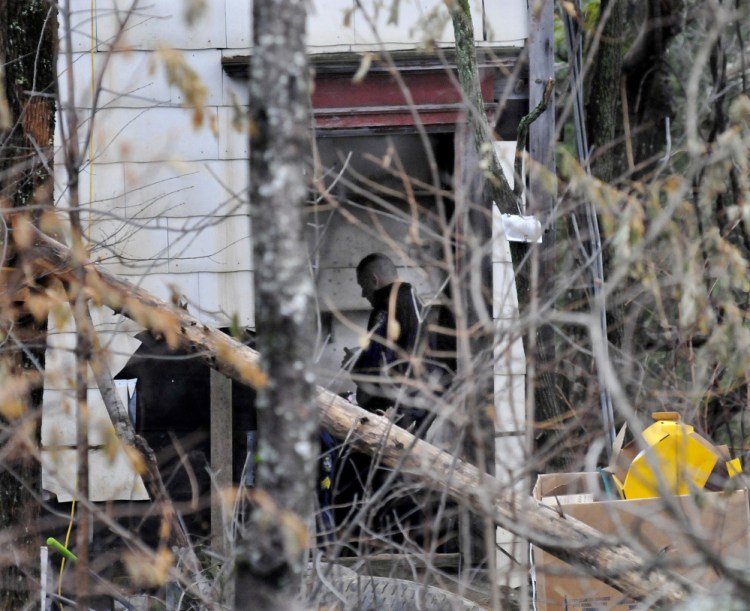 An investigator with the Maine State Police is seen Wednesday inside a run-down home off Route 150 in Skowhegan. Police searched the building and a nearby mobile home Tuesday for any clues about the disappearance of Tina Stadig, who has been missing for more than six months.