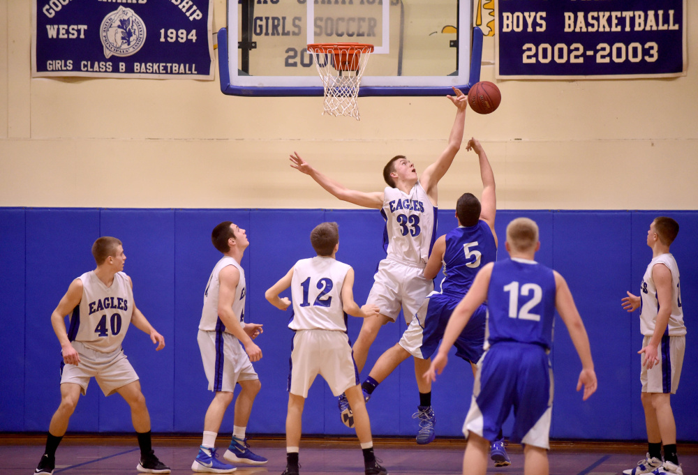 Erskine's Noah Bonsant (33) blocks a shot from Lawrence's Braden Ballard during a Kennebec Valley Athletic Conference Class A game last season in South China.