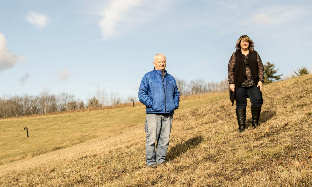 Tammy Murray, Anson administrative assistant, center, and Anson selectman John Bryant, right, pose for a portrait at the former Madison Paper landfill in Anson on Friday. The special town meeting to address the future of the landfill and the $2.4 million to maintain it has been postponed until 6 p.m. Wednesday.