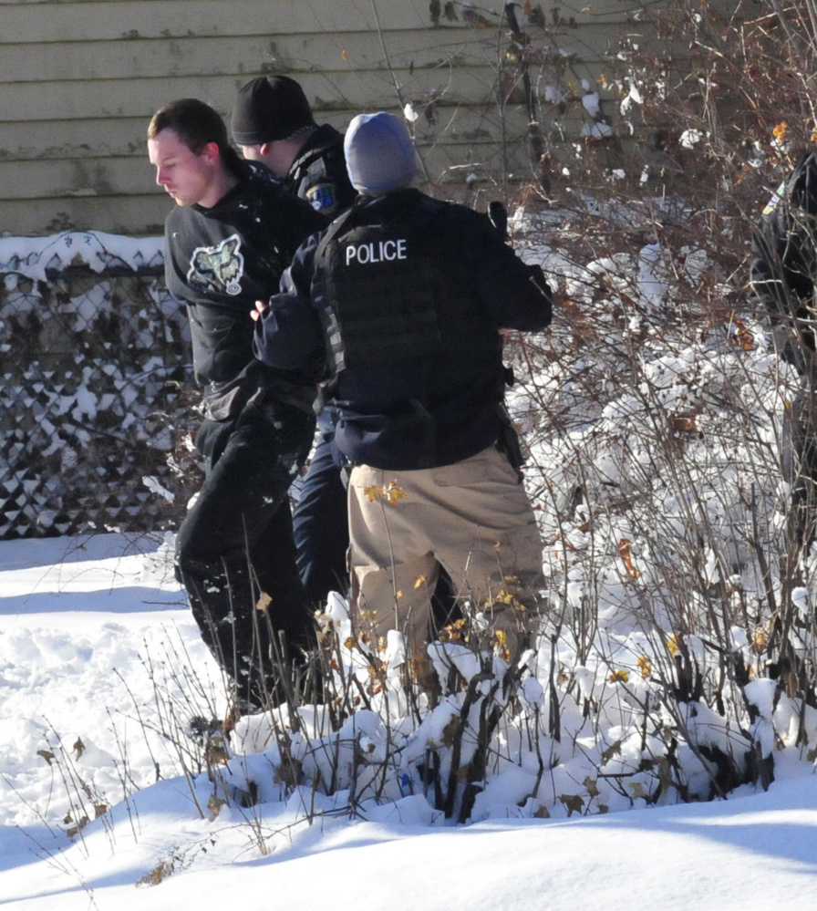 Waterville police arrest Michael Joslyn, left, at 124 College Ave. in Waterville on Sunday after police shot pepper-balls to subdue Joslyn after a 13-hour standoff at the apartment.