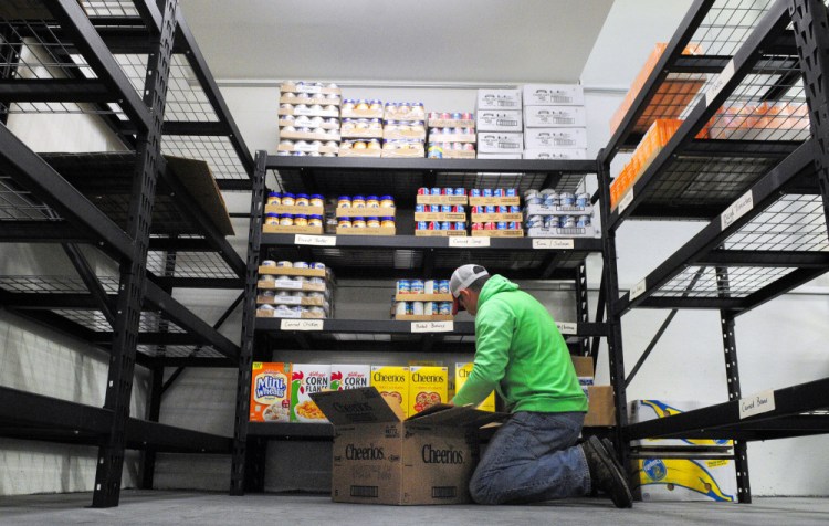 Warehouse manager Andy Waller stocks shelves Tuesday in the new Augusta Food Bank in Augusta.