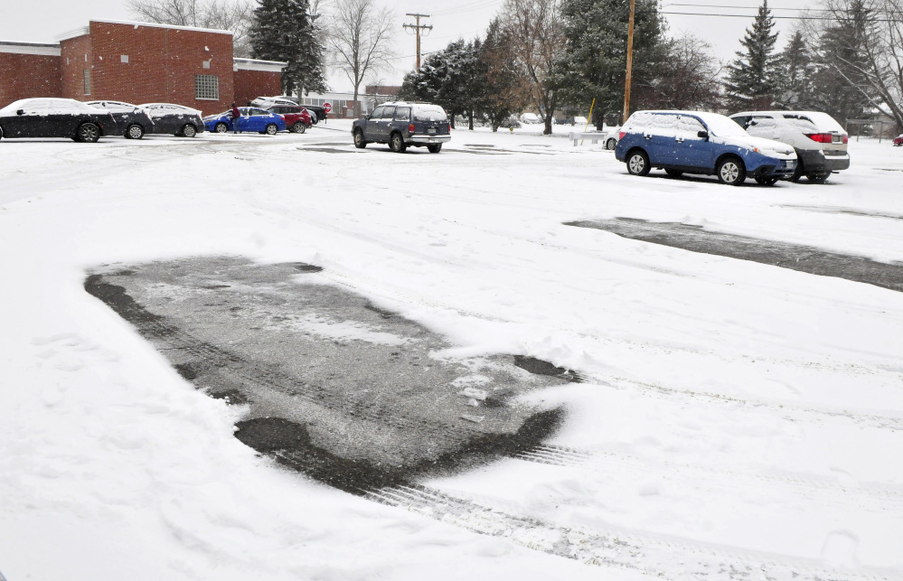 Staff members and students leave one of the parking lots Tuesday at Lawrence High School in Fairfield. It was an early-release day because of a snowstorm.