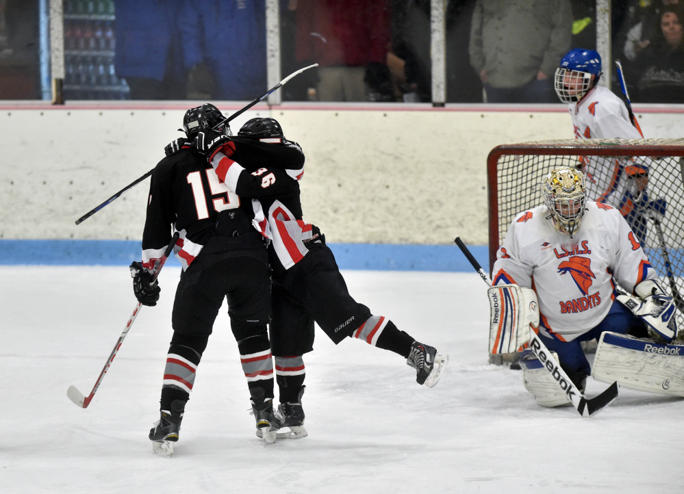 Maranacook/Winthrop forward Sam Johnson , middle, celebrates a first period goal with teammate Nick Bowie during a 2016 game against Lawrence/Skowhegan at Sukee Arena.