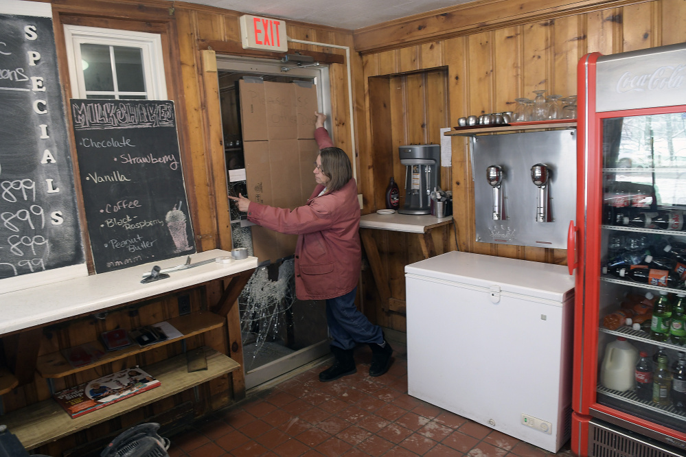 Hi-Hat Pancake House manager Mary Laflin replaces cardboard on a door that was shattered early Tuesday when the Farmingdale restaurant was broken into. An ATM was stolen.