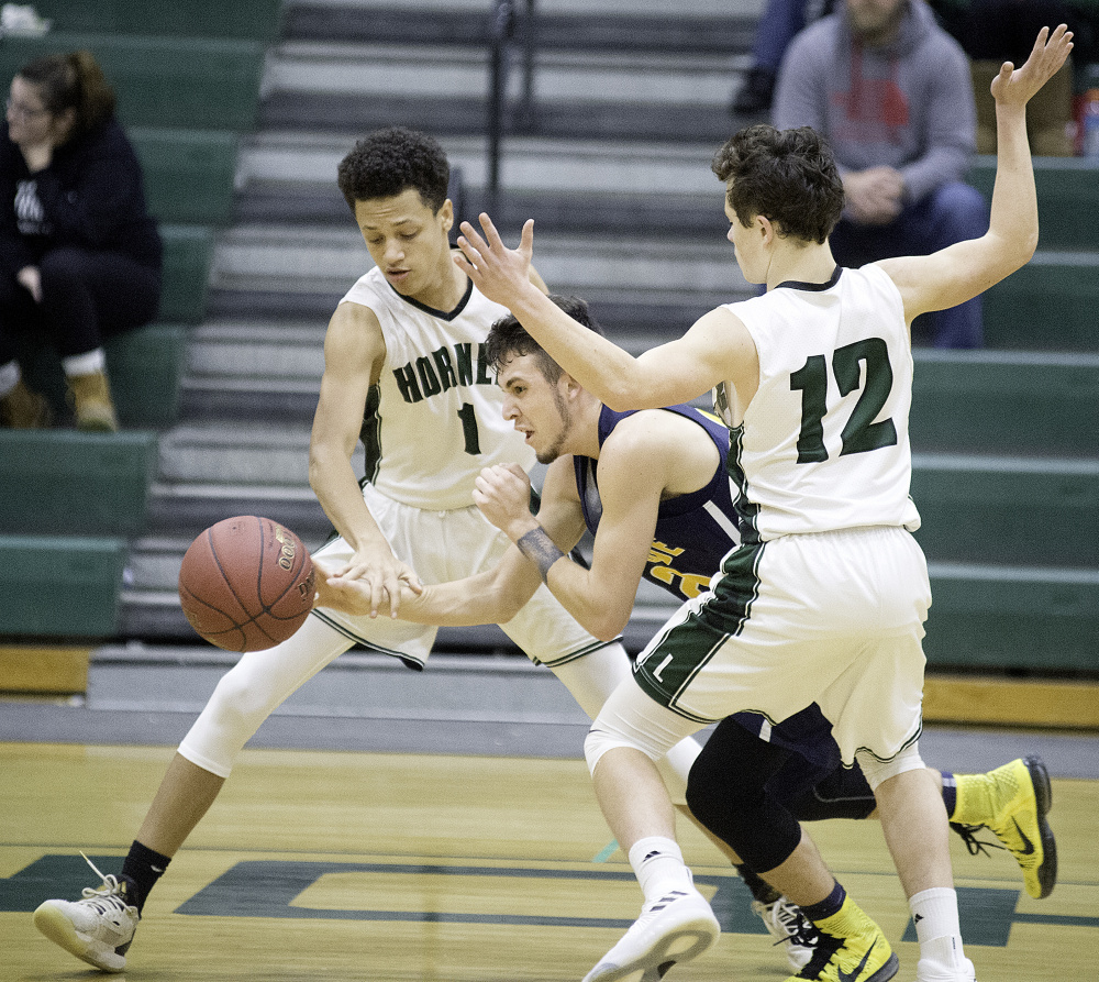 Mt. Blue's Marshall Doyon drives between Leavitt defenders Joziah Learned, left, and Keegan Melanson during a game Tuesday in Turner.