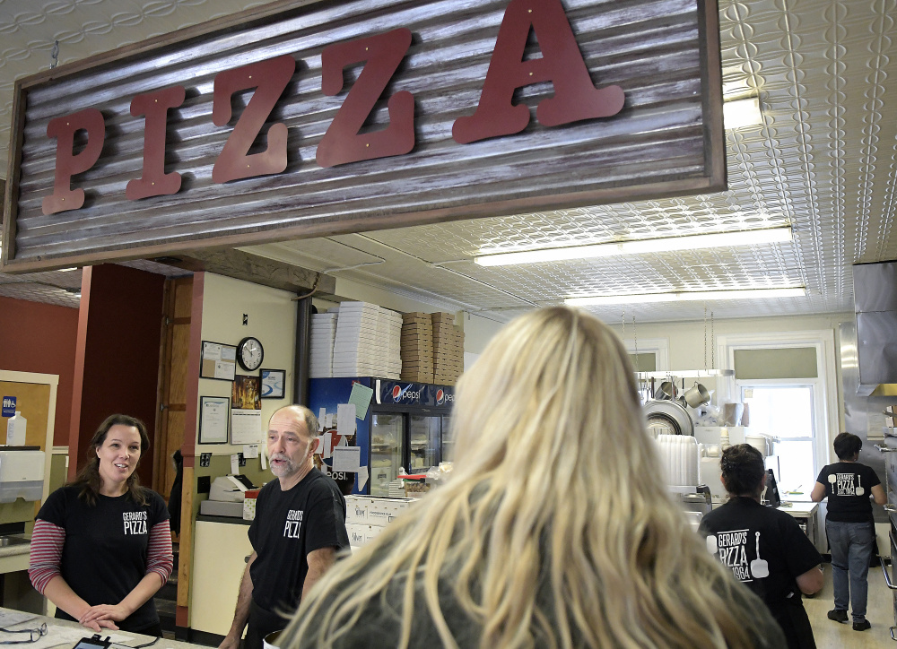 Gerard's Pizza owners Stacy and Claude Caron speak Tuesday with a customer at the Water Street business. The Gardiner institution reopened recently.