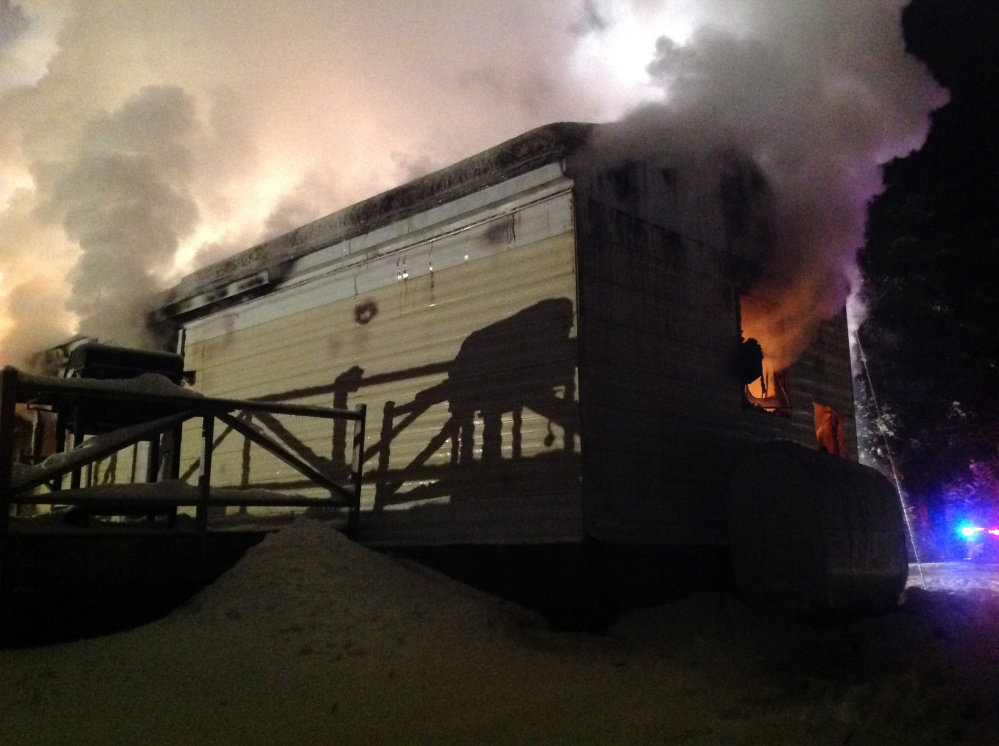 Smoke rises from one side of a structure at 58 Outlet Road in Augusta. Fire destroyed the home Tuesday night.