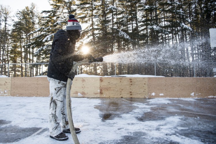 Brent Cook, with the Skowhegan Parks and Recreation Department, prepares the basketball courts for ice Wednesday at the department in Skowhegan.