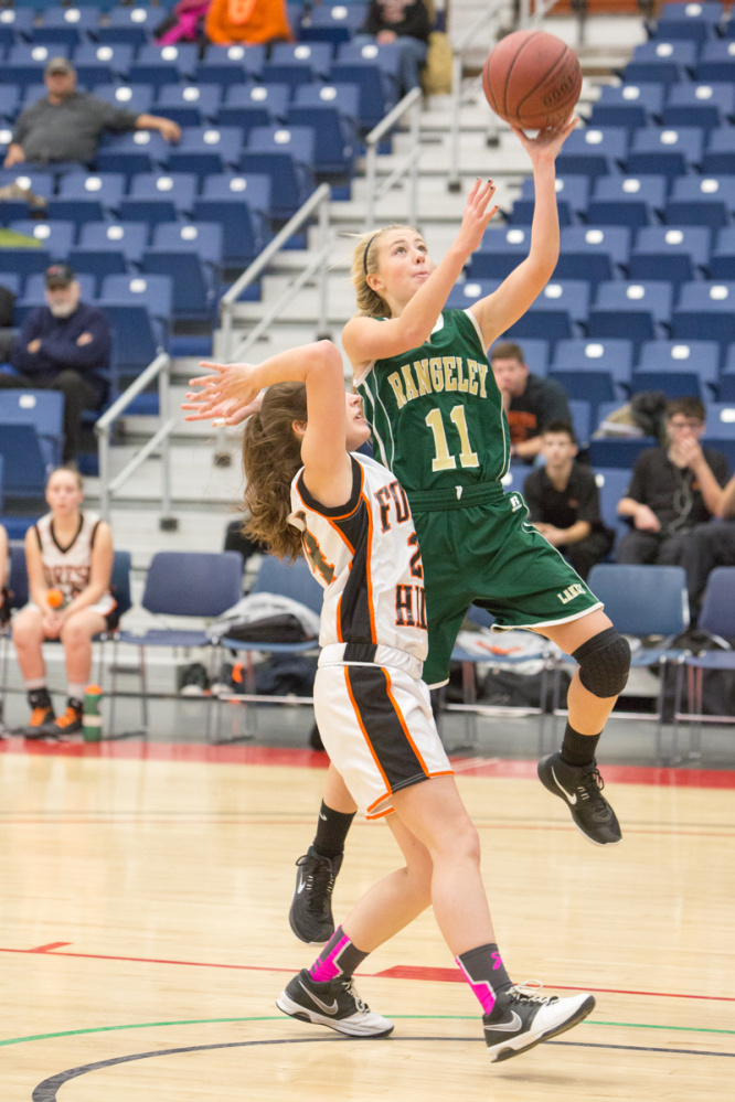 Rangeley's Lauren Eastlack (11) goes up for a layup while being defended by Forest Hills' Alexis Campbell during the Capital City Hoop Classic on Friday at the Augusta Civic Center.