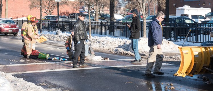 Emergency personnel tend to a woman who was struck by a pickup truck with a plow, right, at the corner of Spruce and Lisbon Streets in Lewiston on Wednesday morning.