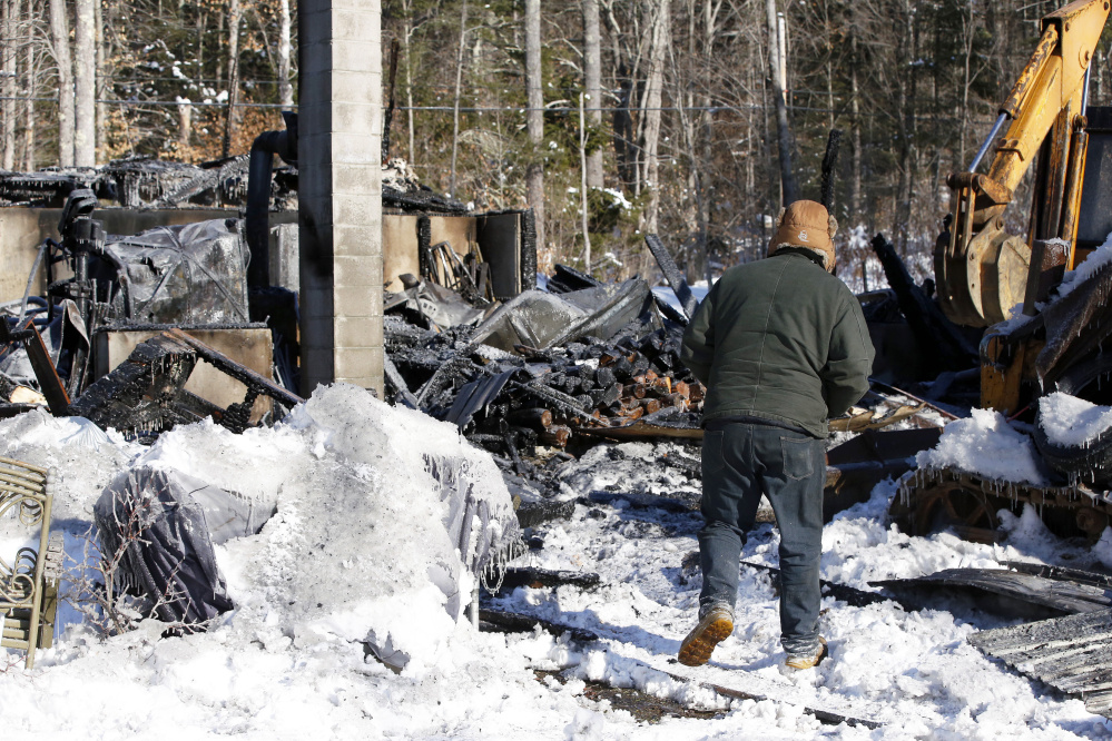 Justin Eastman looks over his family's fire-damaged home on Tuesday morning. No one was injured in the blaze, which began around 12:30 a.m. Tuesday. Eastman's parents designed and built the house in the early 2000s.