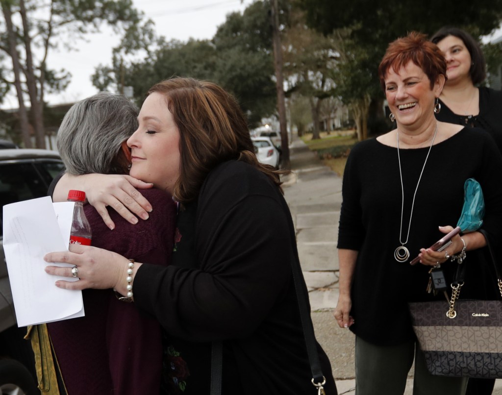 Deyshia Hargrave, facing left, who was arrested for speaking out at a school board meeting this week, hugs a friend before a rally in her support, in Abbeville, La., Thursday.