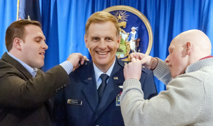 Maine Adjutant General Douglas Farnham, center, smiles as his sons Scott Farnham, left, and Carl Farnham pin another star on his shoulders during his promotion ceremony from brigadier general to major general on Wednesday in Hall of Flags of the State House in Augusta. "I am pleased to recognize General Farnham during this promotion ceremony," Gov. Paul LePage said. "Having earned his well-deserved second star as major general, he is Maine's highest-ranking reserve component officer, leading 3,000 of Maine's National Guard airmen and soldiers."