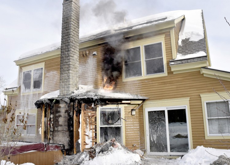Flames spread near a chimney Wednesday after fire rekindled at the Trafton Road home of Susan MacKenzie and Michael Donihue in Waterville.