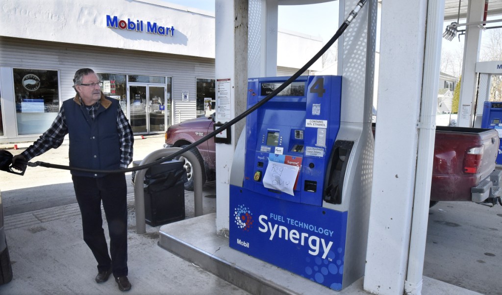 John Craig fills his vehicle with regular 87 octane gas Tuesday at the Mobil Mart in Waterville. A small sign on the pump tells customers that only regular gas is available after diesel and higher octane fuels apparently became mixed recently.