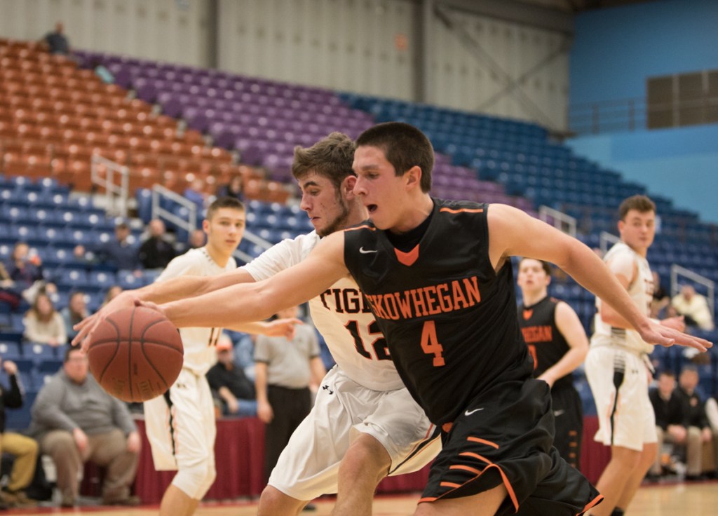 Skowhegan junior Marcus Christopher and Gardiner senior Connor McGuire go for a ball during a game Friday night at the Augusta Civic Center.