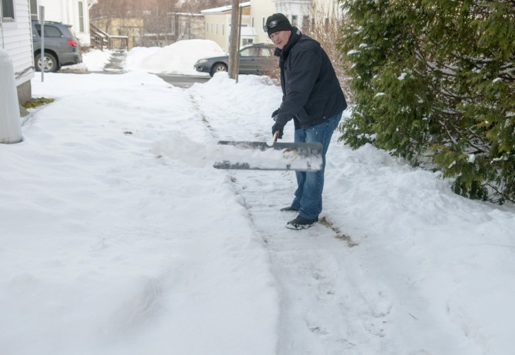 Deputy Chief Jared Mills, of the Augusta Police Department, shovels a walkway Thursday on Crosby Street in Augusta as part of the new Clear Paths and Connected Community volunteer program.