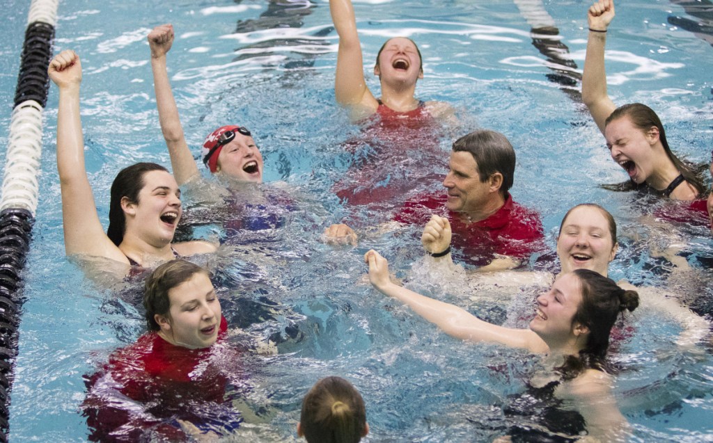 Members of the Cony girls swim team, including coach Jon Millett, take a celebratory swim after winning the Class A state championship last season at Bowdoin College in Brunswick.