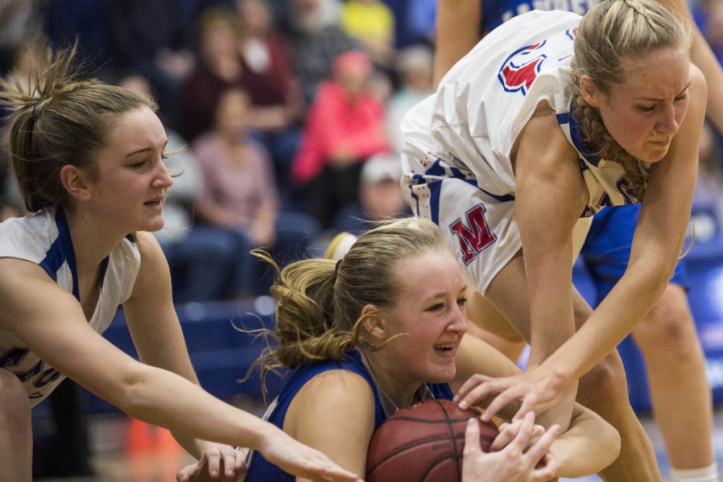 Lawrence's Keagan Alley, center, battles for a loose ball with Messalonskee senior Ally Turner, right, and Brianne Benecke during a Kennebec Valley Athletic Conference Class A game Wednesday night in Oakland.
