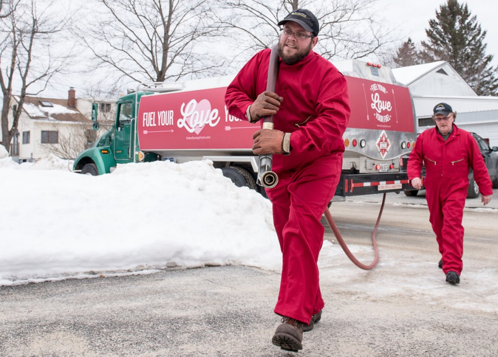 Brandin Daigneault, left, and Roger Pelletier of Murray-Heutz Oil company, deliver free heating oil to Gilman Dube.