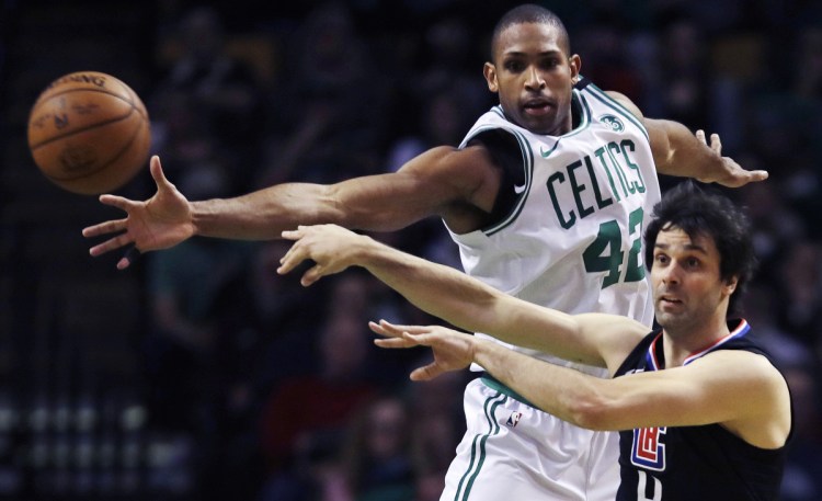 Clippers guard Milos Teodosic, right, passes the ball as he is pressured by Boston's Al Horford in the second quarter Wednesday night in Boston.