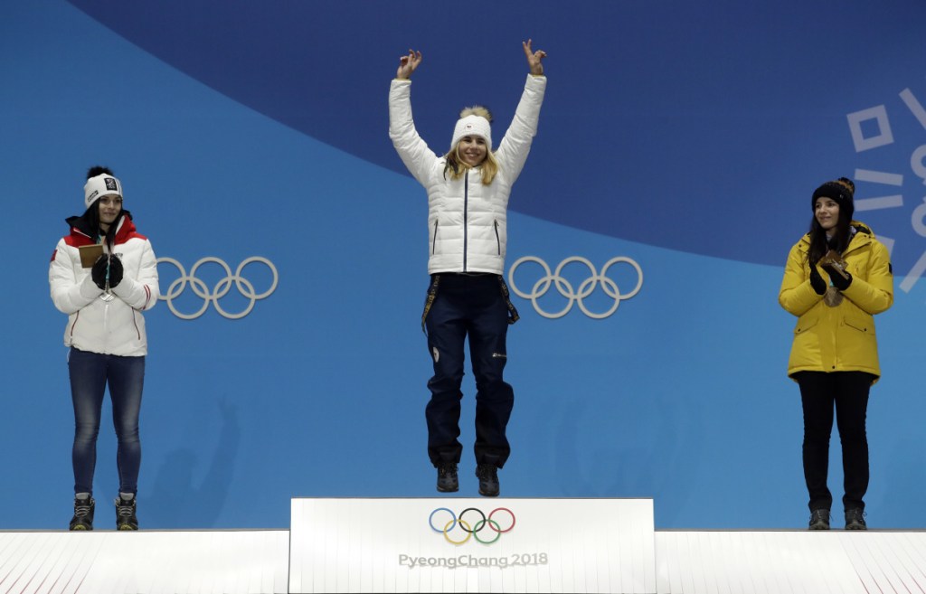 Silver medalist in the women's super-G Anna Veith, left, of Austria, and bronze medalist Tina Weirather, right, of Liechtenstein, applaud as gold medalist Ester Ledecka, of Czech Republic, celebrates during their medals ceremony at the 2018 Winter Olympics in Pyeongchang, South Korea on Saturday.