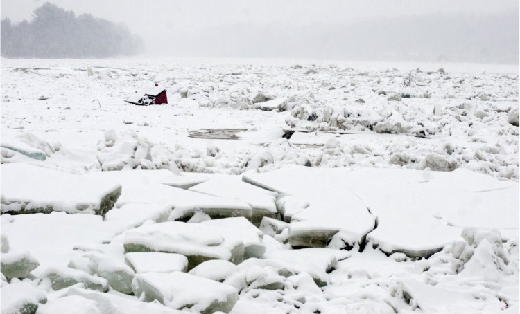 A dumpster that floated away on the Kennebec River from behind the Quarry Tap Room during a Jan. 14 flood lies stuck in the ice behind Cafe De Bangkok on Jan. 17 in Hallowell.