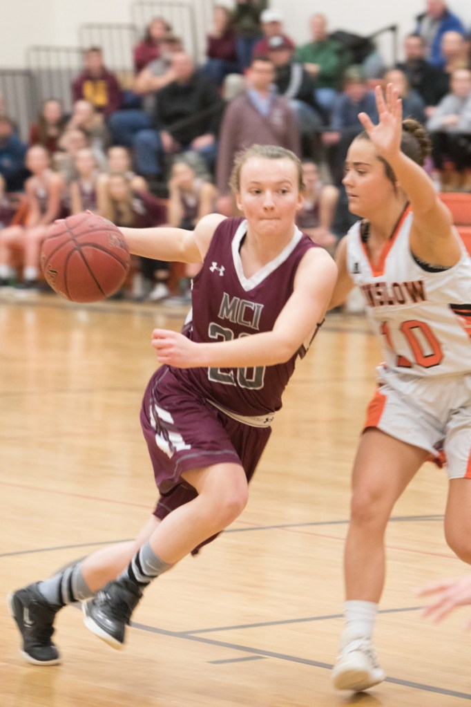 Photo by Jennifer Bechard 
 MCI's Sydney Morton, left, goes in for a layup while Winslow's Sarah Guimond defends during a Class B North game Thursday night in Winslow.