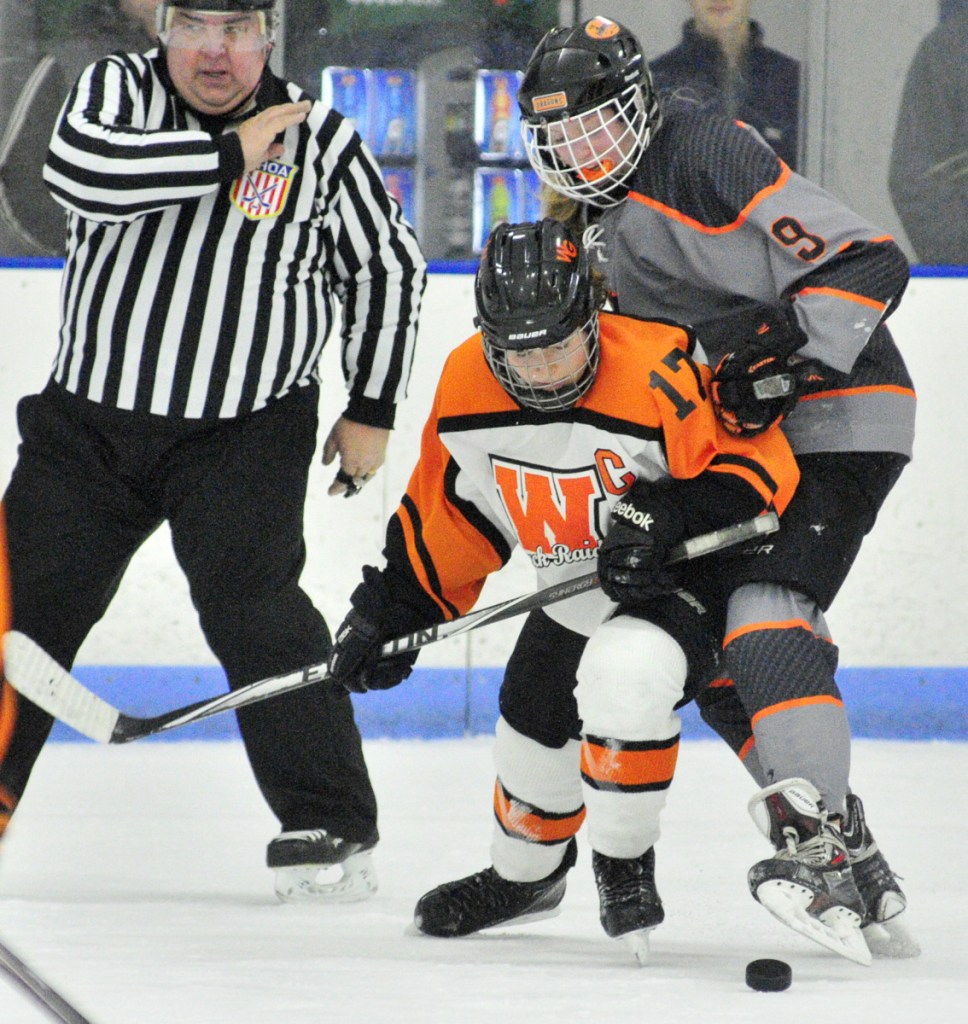 Winslow/Gardiner's Evelyn Hinkley and Brunswick's Tash Schneider get after a loose puck during a North quarterfinal game Thursday at the Camden National Bank Ice Vault in Hallowell.