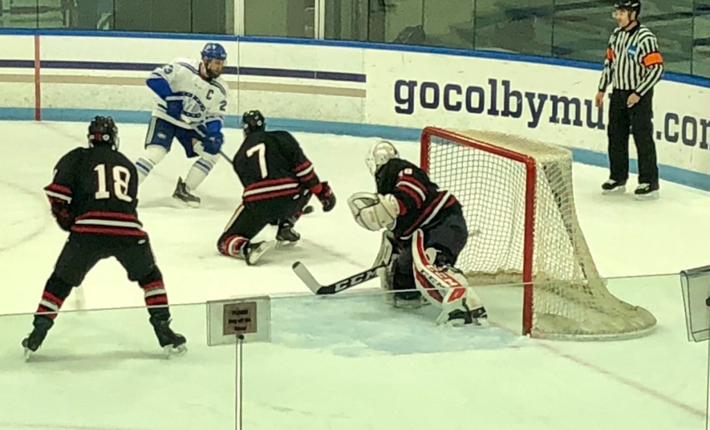 Staff photo by Travis Barrett 
 Colby College's Phil Klitirinos (top) creates a scoring chance against Wesleyan as Cardinals Tyler Watt (18) and Chad Malinowski (7) defend in front of goaltender Tim Sestak on Sunday at Alfond Rink.