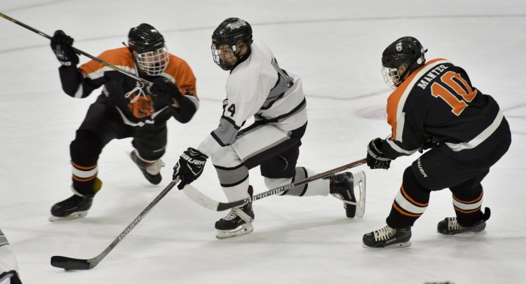 Staff photo by David Leaming 
 Kennebec's Hunter Brown, middle, skates between Gardiner defenders, including Conner Manter at right, during a game Monday at Colby College.