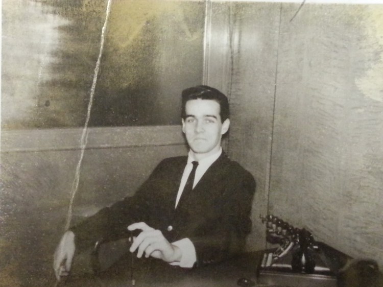 J.P. Devine at the desk at the end of a long hall full of empty offices that might have been a front for nefarious activities.