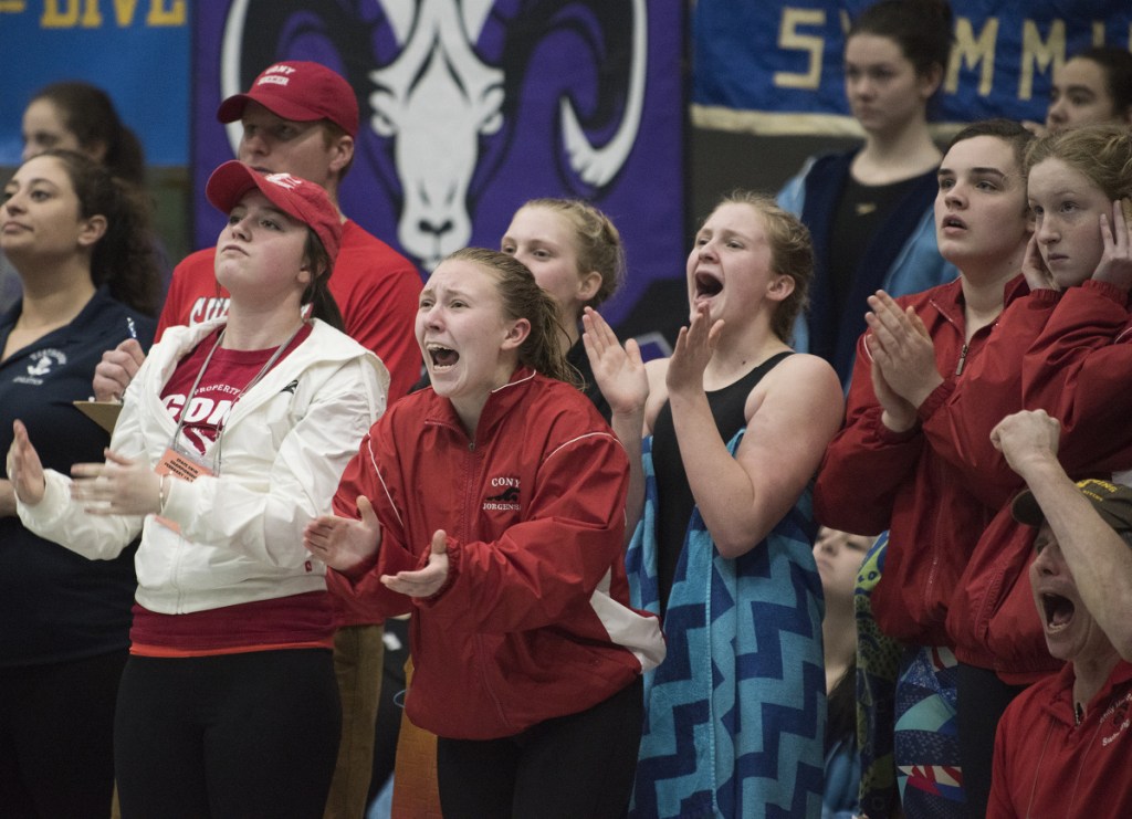 Members of the Cony High girls swim team cheer on Talia Jorgensen as she competes in the 200-yard freestyle during the Class A state championship meet Monday in Orono.