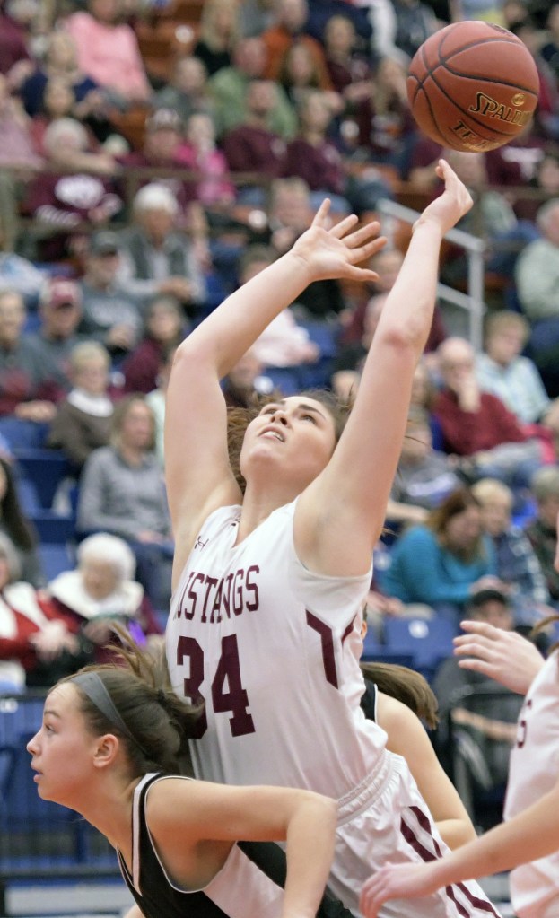 Monmouth's Destiny Clough reaches for the ball on the back of St. Dominic's Rileigh Stebbins during a Class C South quarterfinal game Tuesday at the Augusta Civic Center.