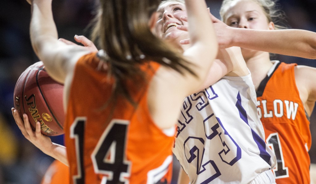 John Bapst's Abbey Legasse (23) drives to the basket as Winslow's Madison Roy (14) defends during a Class B North semifinal game Wednesday at the Cross Center in Bangor.
