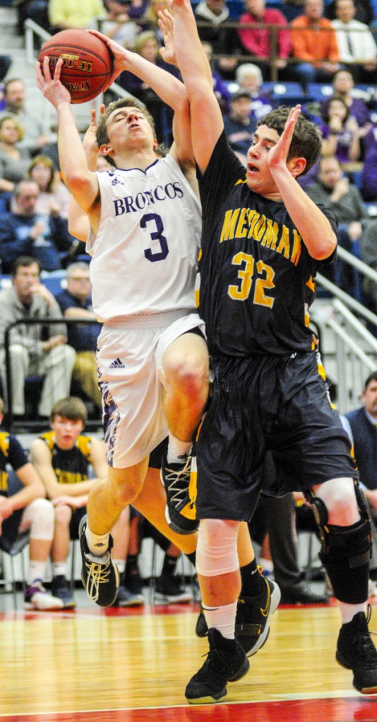 Hampden Academy's Kory Winch, left, shoots over Medomak's Nathan Emerson during the Class A North championship game Friday night at the Augusta Civic Center.