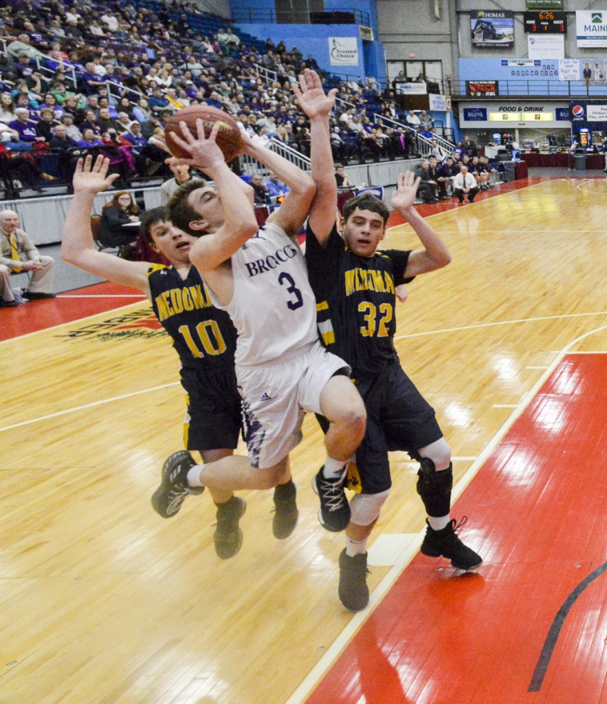 Medomak Valley's Jordan Powell, left, and Nathan Emerson, right, defend Hampden's Kory Winch during the Class A North championship game Friday night at the Augusta Civic Center.