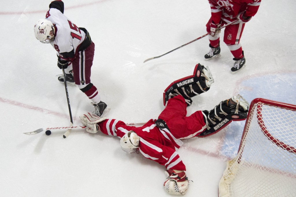 Cony goalie Dalton Bowie (1) makes a save as Bangor's Alex Inman (15) looks for the rebound score Tuesday at Sawyer Arena in Bangor.
