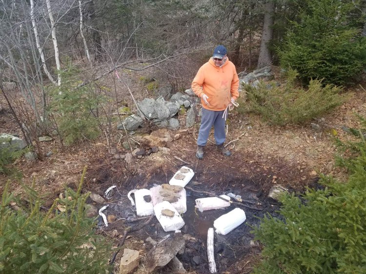 Chris Anderson looks over one of the many puddles of oil that remain from a Dec. 18 oil spill in Port Clyde. 