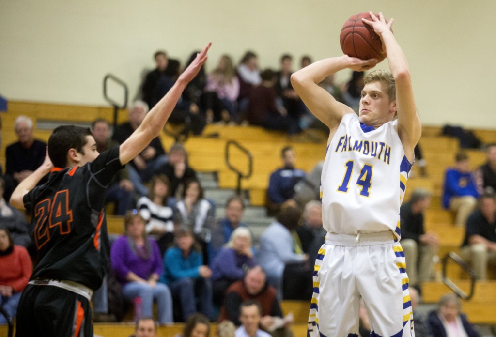 FALMOUTH, ME - DECEMBER 20: Brunswick junior Kyle Hanson (24) tries to block Falmouth freshman Michael Simonds (14) as he makes shot during the game at Falmouth High School. Falmouth won 54-36. (Photo by Brianna Soukup/Staff Photographer)