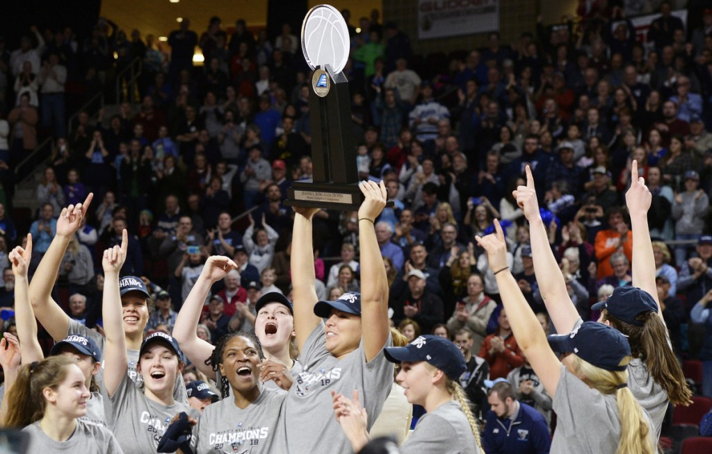 The University of Maine women's basketball team celebrates with the America East trophy after their victory over Hartford on Friday in Bangor.