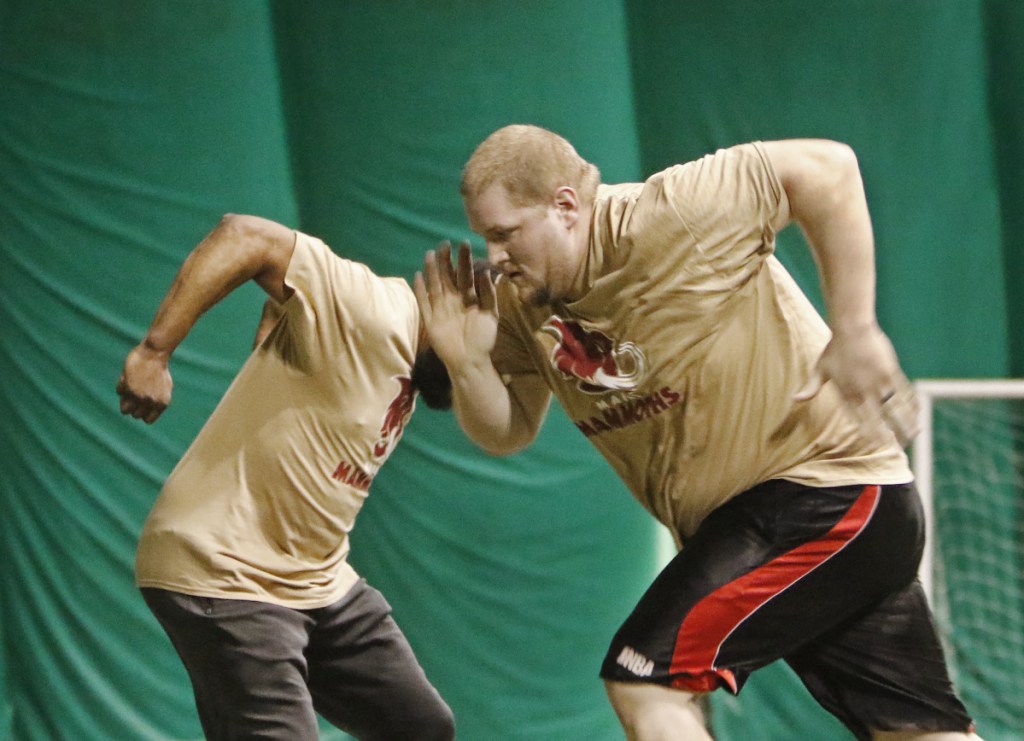 Mike Roberts of Waterville, right, and Phil Warren of Brunswick practice a lineman drill during local tryouts Sunday for Maine's new indoor football team, the Mammoths, at Seacoast United of Topsham.
