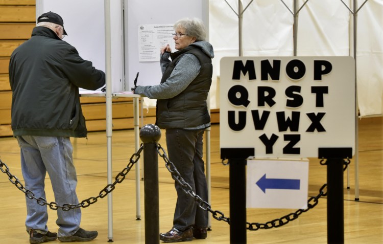 Bill and Mary Ann Trafton vote Tuesday at Waterville Junior High School in the Alternative Organizational Structure 92 referendum, which, if approved, would dissolve the system Waterville shares with Winslow and Vassalboro.