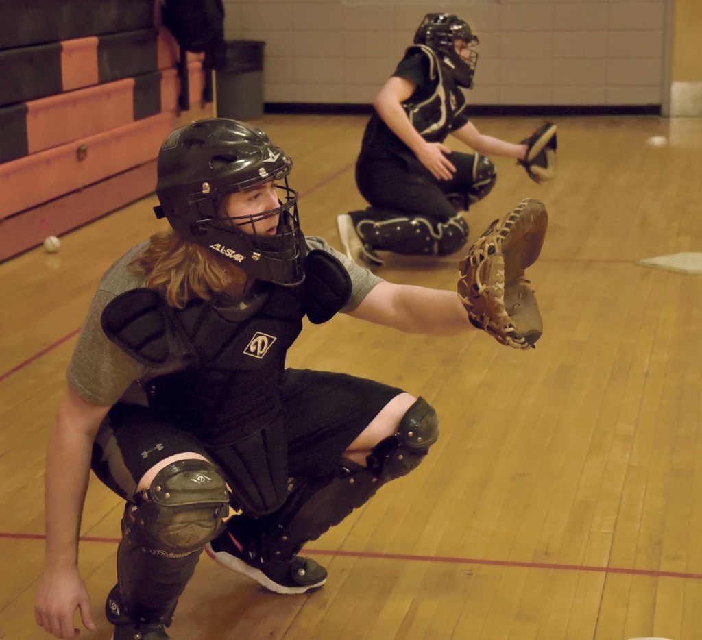 Winslow catchers Nick West, left, and Bryce Gunzinger get some work in Monday afternoon at the high school.