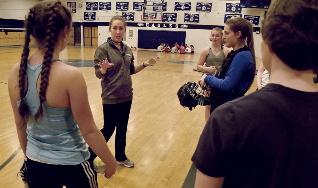 Messalonskee softball coach Samantha Moore instructs team pitchers and catchers during Monday in Oakland.