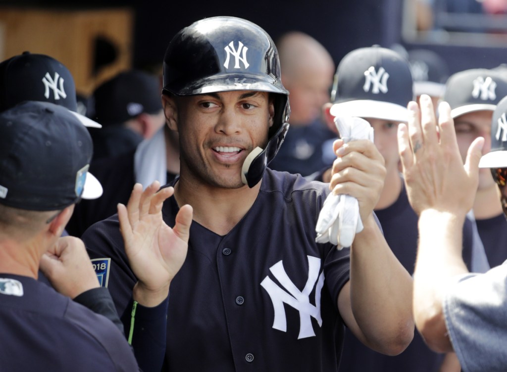 New York Yankees' slugger Giancarlo Stanton is congratulated after scoring on a single by Didi Gregorius during the fifth inning against the Atlanta Braves in spring training in Tampa, Florida. After last season the Yankees added the mightiest slugger in the major leagues, Stanton.