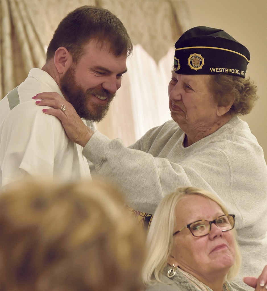 Veterans advocate Travis Mills gets a hug from Mary "Dottie" McGuirk, a 20-year Air Force nurse who served in Southeast Asia during the Vietnam War, during a National Vietnam Veterans Day celebration Thursday in Waterville.