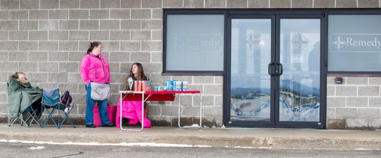 Stacy Lahr, center, of Lewiston stands Friday morning in front of Remedy Compassion Center, a medical marijuana dispensary in Auburn. Lahr is shown with her daughters Margaret Sidelinger, left, and Madison Binette, who is a member of Girl Scout Troop 2470. (Russ Dillingham/Sun Journal)